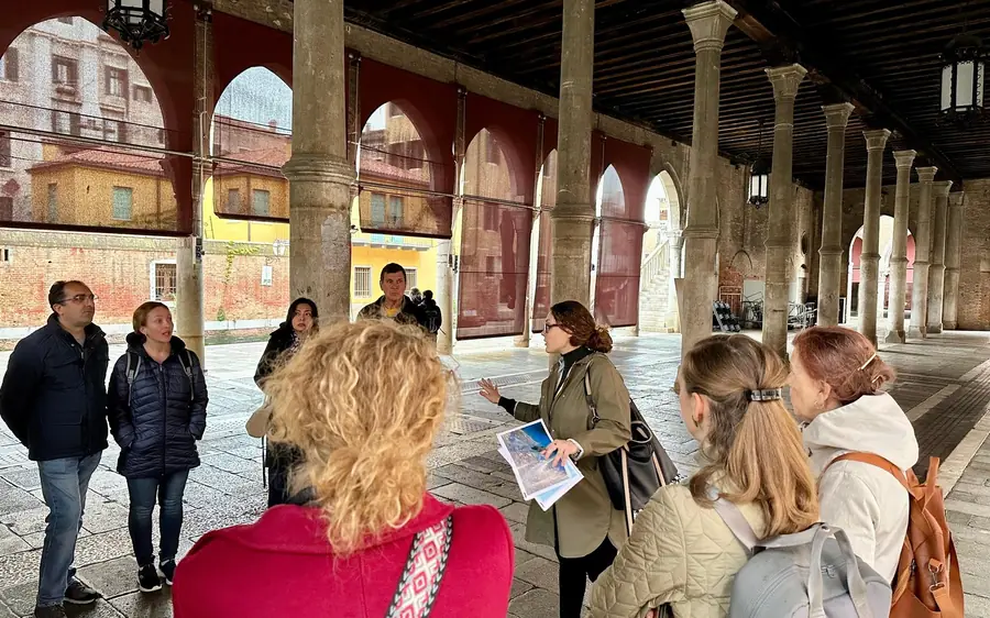 A small group walking a narrow Venetian lane with a guide