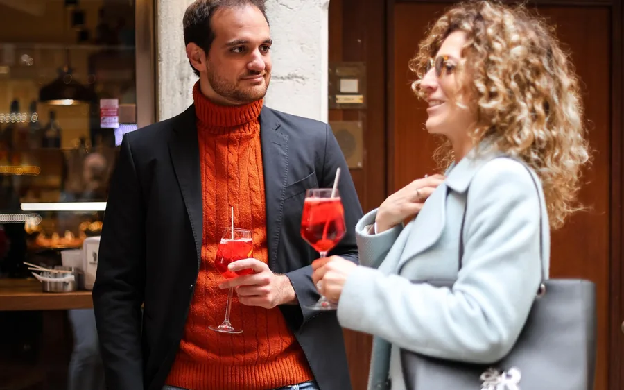 A spritz and small plates on a Venetian table